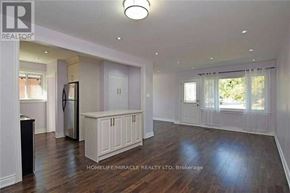 Brampton (Brampton South) apartment for rent - A spacious living room with wood flooring and white walls.