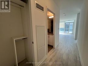 Toronto (Waterfront Communities) condo for rent - A hallway with a door on the left and a window on the right.