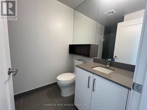 Toronto (Waterfront Communities) condo for rent - A bathroom with a toilet, sink, and mirror.
