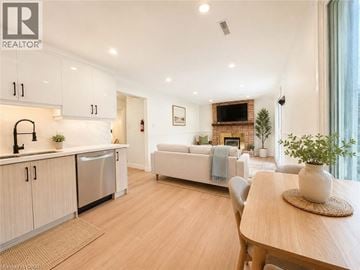 Dundas apartment for rent - A modern kitchen with white cabinets and a wooden dining table.