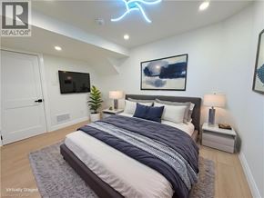 Dundas apartment for rent - A bedroom with a bed, a television, and a plant.