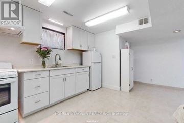 Richmond Hill (North Richvale) apartment for rent - A white kitchen with a sink, refrigerator, and cabinets.