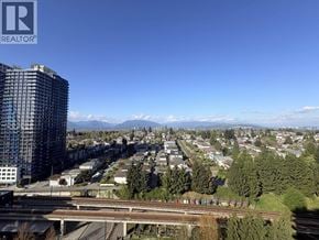 Vancouver apartment for rent - A cityscape with a tall building on the left and a highway in the foreground.