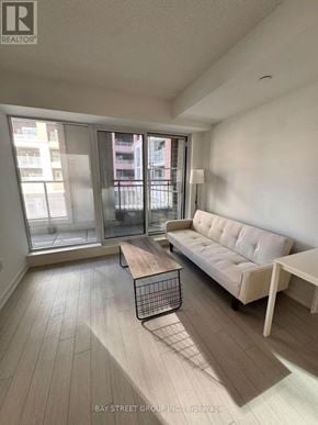 Toronto (Humber Heights) condo for rent - A living room with a white couch and a wooden coffee table.