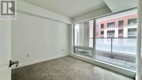 Toronto (Humber Heights) condo for rent - A room with a large window and a view of a red building across the street.