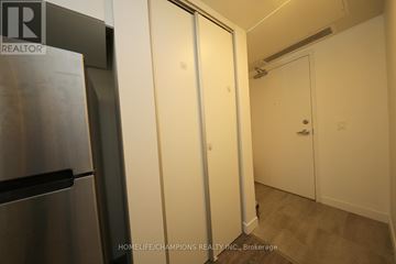 Waterloo condo for rent - A kitchen area with a refrigerator and a door leading to another room.