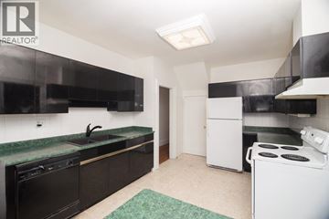 Vancouver apartment for rent - A kitchen with black cabinets and a green countertop.