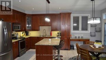 Oakville (Bc Bronte Creek) apartment for rent - A kitchen with wooden cabinets and a granite countertop.
