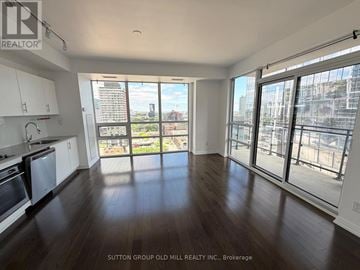 Toronto (Moss Park) condo for rent - A spacious kitchen and living room with wooden floors and large windows.