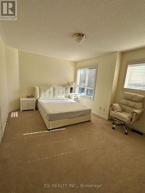 Markham (Wismer) apartment for rent - A bedroom with a bed, chair, and nightstand.