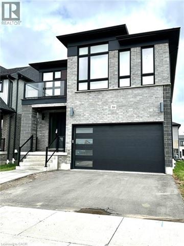 Kitchener apartment for rent - A modern house with a black garage door is for sale.