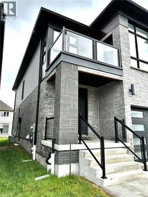 Kitchener apartment for rent - A modern house with a glass balcony and a stone facade.