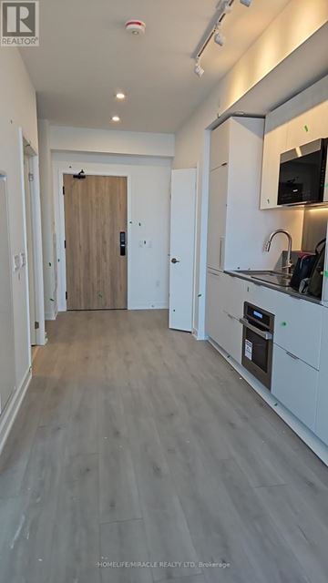 Mississauga (Mississauga Valleys) condo for rent - A kitchen with white cabinets and a wooden door.