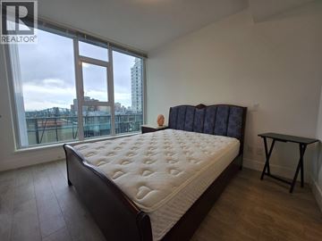 Burnaby apartment for rent - A bedroom with a large bed and a small table.