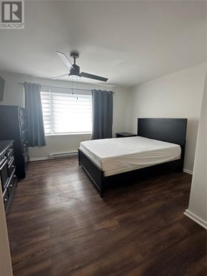 St. John's apartment for rent - A bedroom with a bed, dresser, and ceiling fan.