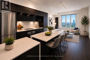 Toronto (Regent Park) condo for rent - A modern kitchen with a large island and a view of the city.