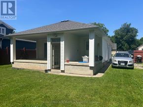 Oakville (Co Central) apartment for rent - A small white house with a porch and a car parked in front.