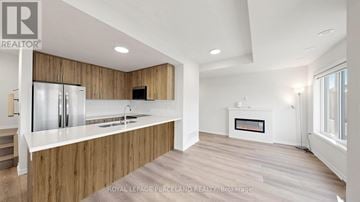Richmond Hill (Headford Business Park) townhouse for rent - A modern kitchen with wooden cabinets and a white countertop.