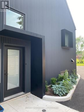 Niagara Falls (Cherrywood) apartment for rent - A modern house with a black exterior and a glass door.