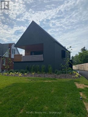 Niagara Falls (Cherrywood) apartment for rent - A modern house with a grey exterior and a well-maintained lawn in front.