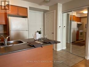 Mississauga (City Centre) condo for rent - A kitchen with a sink, refrigerator, and cabinets.