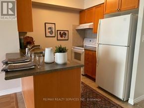 Mississauga (City Centre) condo for rent - A kitchen with a refrigerator, sink, and cabinets.