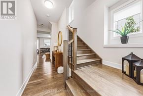 Burlington (Rose) townhouse for rent - A hallway with a wooden staircase and a plant on the windowsill.