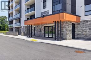 Windsor condo for rent - A modern building with a glass entrance and a stone wall.