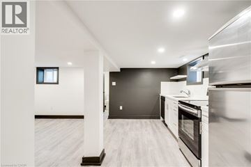 Hamilton apartment for rent - A modern kitchen with white cabinets and a black backsplash.
