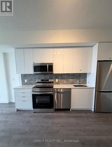 Brantford condo for rent - A kitchen with white cabinets and stainless steel appliances.