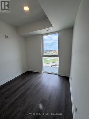 Brantford condo for rent - A room with a view of a parking lot through a window.
