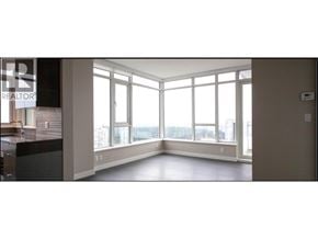Burnaby apartment for rent - A large empty room with a view of the city through the windows.