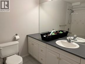 Vancouver apartment for rent - A bathroom with a white toilet, a black countertop, and a white sink.