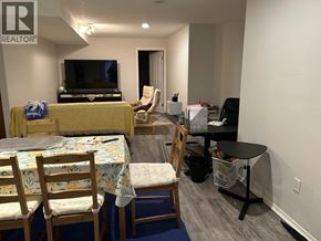 Vancouver apartment for rent - A living room with a couch, chairs, and a television.