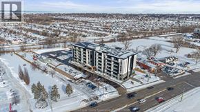 Windsor condo for rent - A large building with a parking lot in front of it.