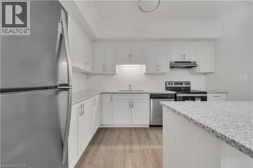 Cambridge townhouse for rent - A kitchen with white cabinets and a marble countertop.