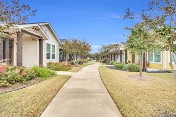 Waxahachie apartment for rent - A row of houses with a sidewalk in front.