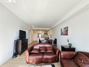 Langley apartment for rent - A living room with a brown leather couch and a television.