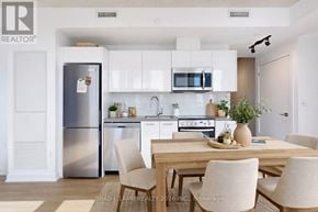 Toronto (Moss Park) condo for rent - A modern kitchen with a dining table set for two.