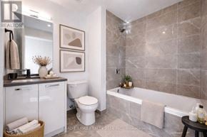 Toronto (Moss Park) condo for rent - A bathroom with a tub, toilet, and sink.
