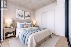 Toronto (Moss Park) condo for rent - A bedroom with a bed, nightstands, and a painting on the wall.