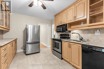 Toronto (Ionview) apartment for rent - A kitchen with wooden cabinets and a black stove top oven.