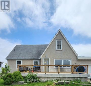 Welland (Broadway) triplex for rent - A house with a grey roof and a white wall with a window and a door.