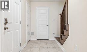 Milton (Fo Ford) townhouse for rent - A hallway with a white door and a wooden staircase.