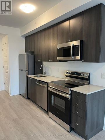 Milton (Walker) condo for rent - A modern kitchen with dark wood cabinets and stainless steel appliances.