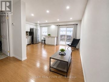 Kitchener townhouse for rent - A living room with a black coffee table and a chair.