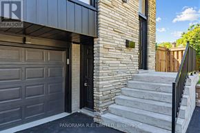 Mississauga (Cooksville) apartment for rent - A house with a black garage door and a brick wall.