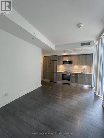 Toronto (Church-Yonge Corridor) condo for rent - A spacious kitchen with wooden cabinets and a modern design.