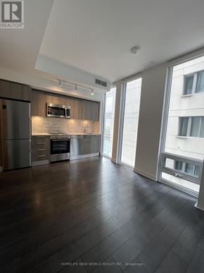 Toronto (Church-Yonge Corridor) condo for rent - A spacious kitchen with dark wood floors and stainless steel appliances.