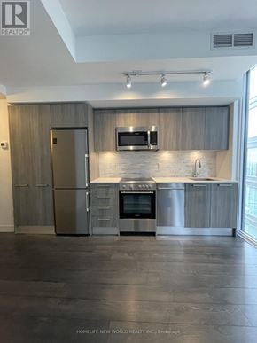 Toronto (Church-Yonge Corridor) condo for rent - A modern kitchen with stainless steel appliances and wooden cabinets.